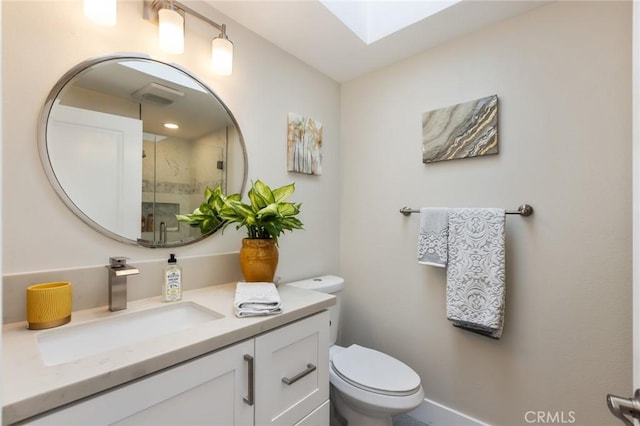 bathroom featuring vanity, a shower with shower door, toilet, and a skylight