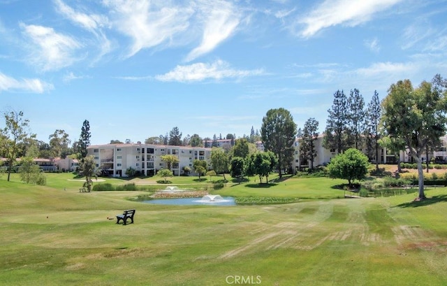 view of home's community with a water view and a lawn