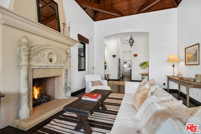 living room with high vaulted ceiling, a fireplace, hardwood / wood-style flooring, wood ceiling, and beam ceiling