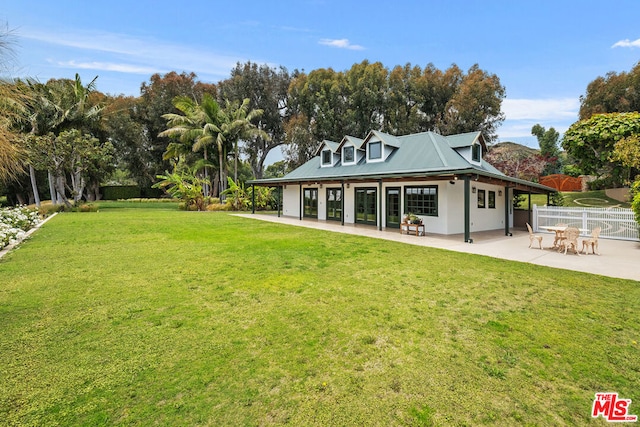 rear view of property with a yard and a patio