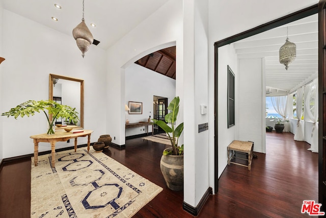 hallway featuring high vaulted ceiling and dark hardwood / wood-style flooring