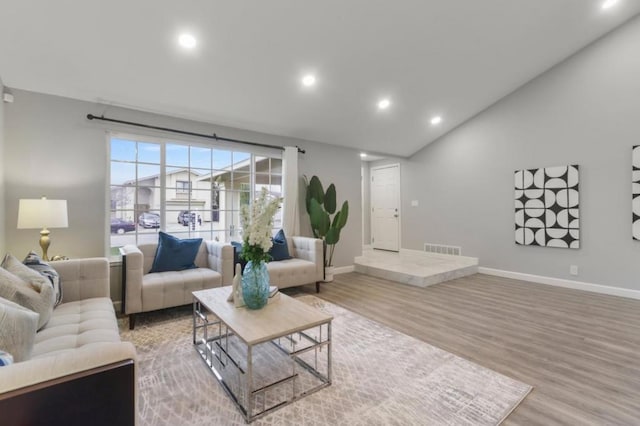 living room featuring vaulted ceiling and hardwood / wood-style floors