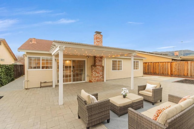 back of house featuring outdoor lounge area and a patio