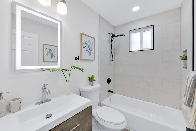 full bathroom featuring tiled shower / bath, vanity, and toilet