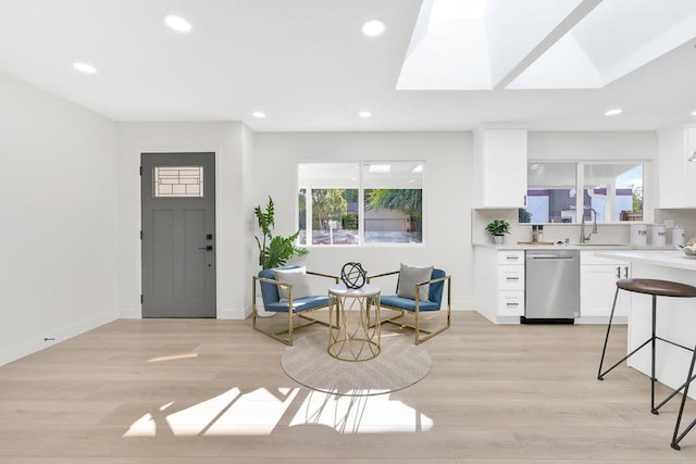 living room featuring plenty of natural light, light hardwood / wood-style floors, and sink