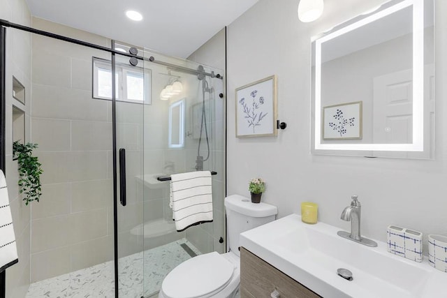 bathroom with walk in shower, vanity, and toilet