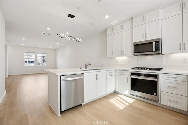 kitchen with white cabinetry, decorative light fixtures, and appliances with stainless steel finishes