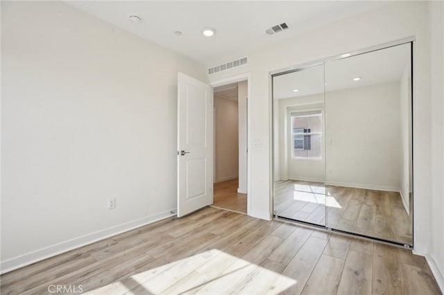 unfurnished bedroom featuring a closet and light hardwood / wood-style flooring