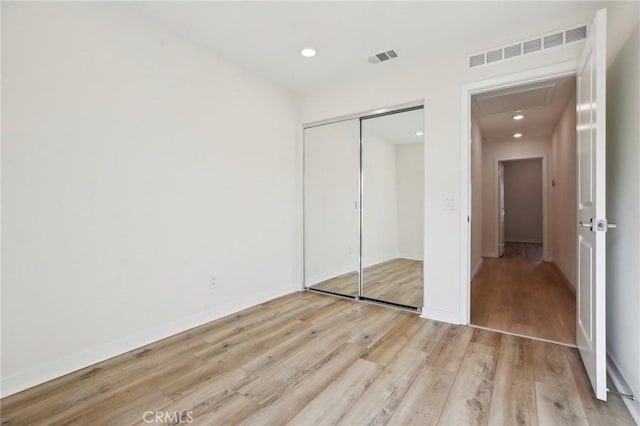 unfurnished bedroom featuring a closet and light hardwood / wood-style flooring