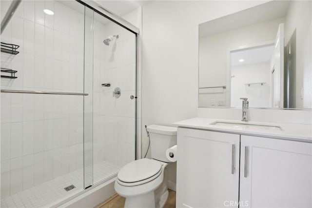 bathroom featuring vanity, toilet, and an enclosed shower