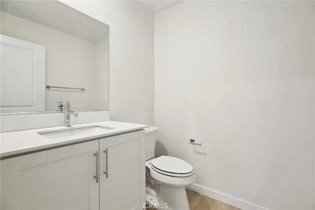 bathroom with vanity, hardwood / wood-style flooring, and toilet