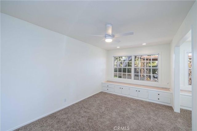 carpeted spare room featuring ceiling fan