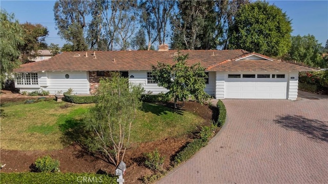 ranch-style house with a garage and a front yard