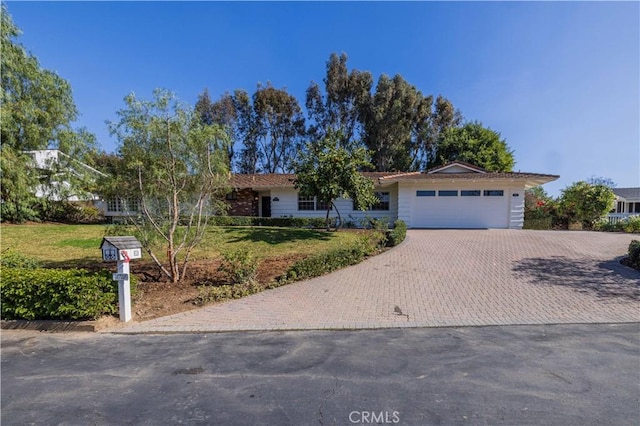 single story home featuring a garage and a front lawn