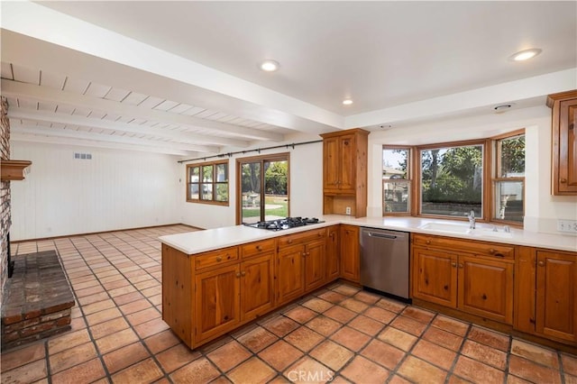 kitchen featuring sink, beam ceiling, gas stovetop, stainless steel dishwasher, and kitchen peninsula