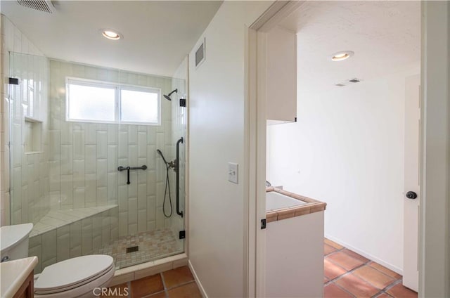 bathroom with vanity, a shower with door, tile patterned floors, and toilet