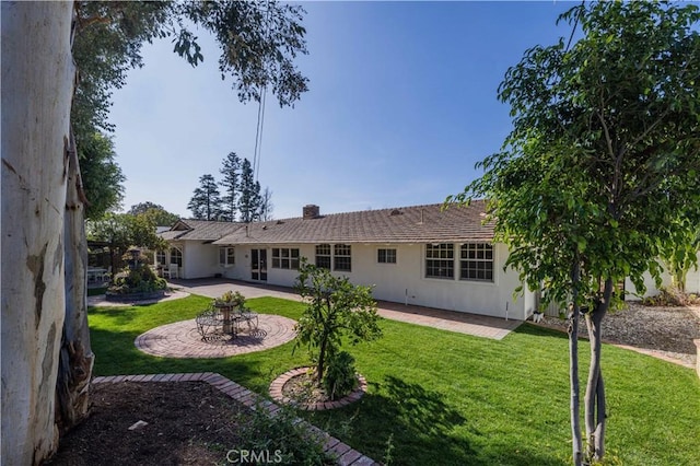 rear view of house featuring a yard and a patio area