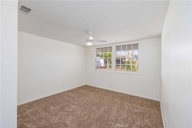 empty room with a textured ceiling, ceiling fan, and carpet