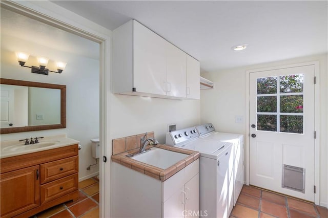 laundry area with separate washer and dryer, sink, light tile patterned floors, and cabinets