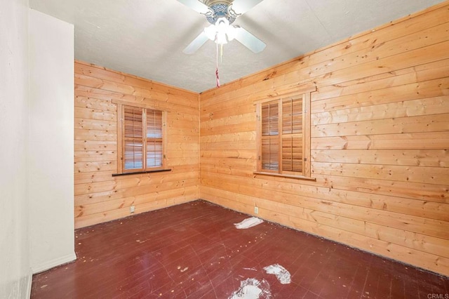 unfurnished room with dark hardwood / wood-style flooring, ceiling fan, and wooden walls