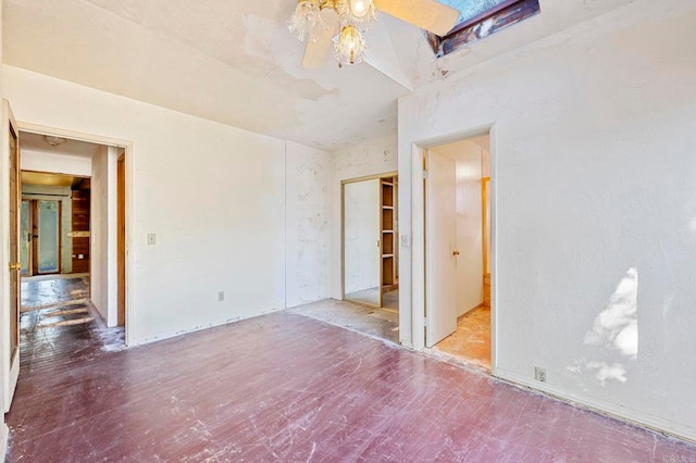 unfurnished room with ceiling fan and a skylight