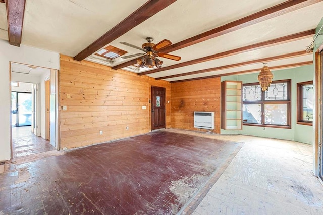 unfurnished living room with heating unit, plenty of natural light, wooden walls, and beamed ceiling