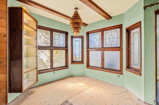 unfurnished sunroom with beamed ceiling