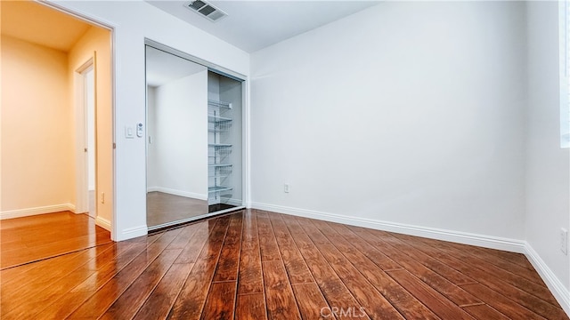 unfurnished bedroom with hardwood / wood-style floors and a closet