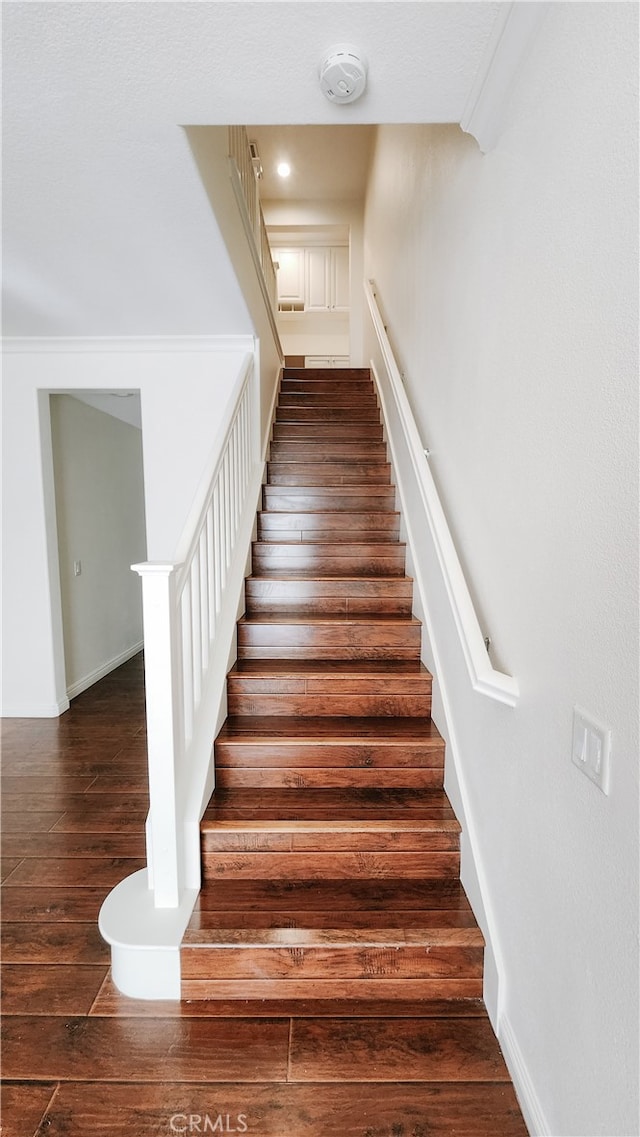 staircase featuring wood-type flooring