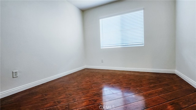 spare room featuring dark wood-type flooring