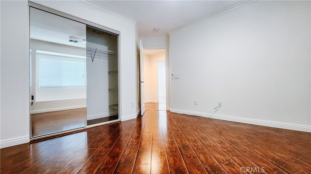 unfurnished bedroom with crown molding, dark hardwood / wood-style floors, and a closet