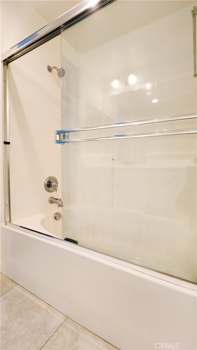 bathroom with shower / bath combination with glass door and tile patterned flooring