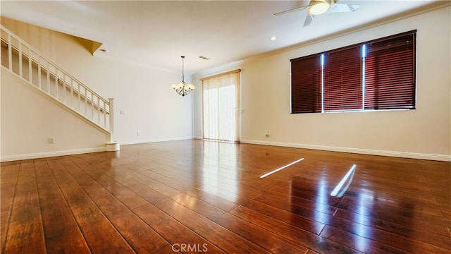 unfurnished room featuring ceiling fan with notable chandelier, wood-type flooring, and ornamental molding