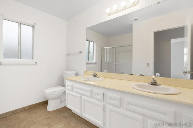 bathroom featuring vanity, toilet, an enclosed shower, and tile patterned flooring