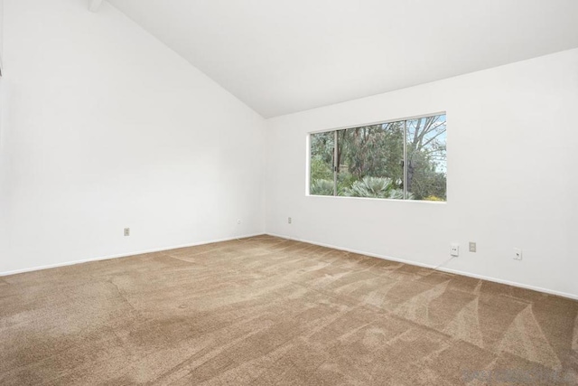 spare room featuring lofted ceiling and carpet