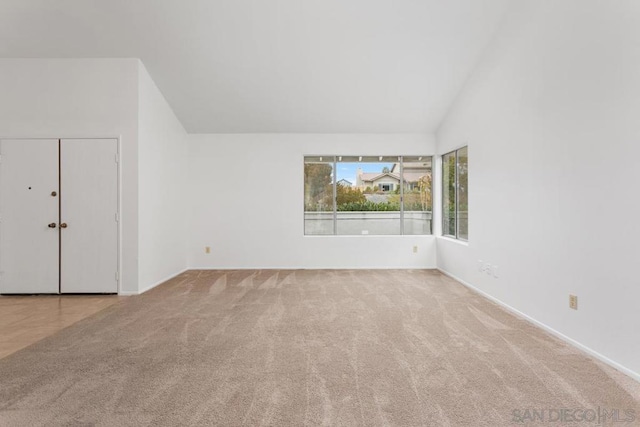 interior space featuring light carpet and high vaulted ceiling