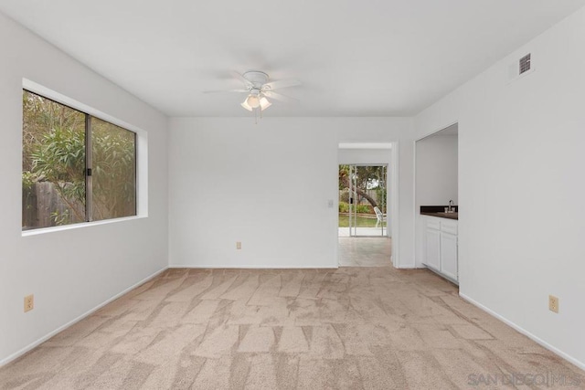 spare room featuring ceiling fan and light carpet