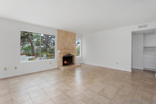 unfurnished living room featuring a tiled fireplace