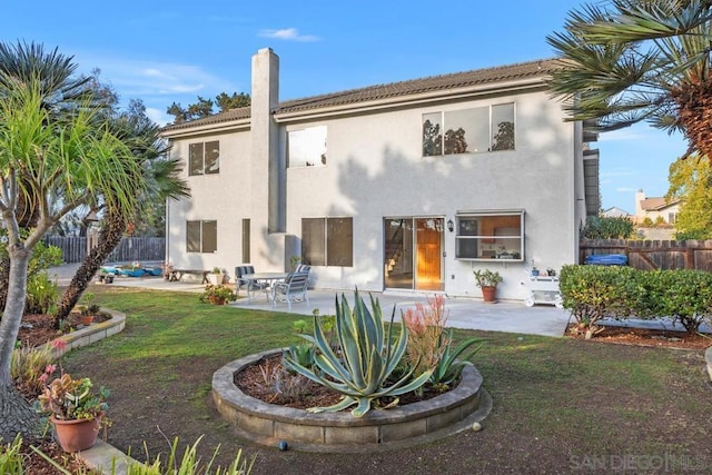 back of house with a yard and a patio