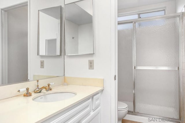 bathroom featuring vanity, toilet, and walk in shower