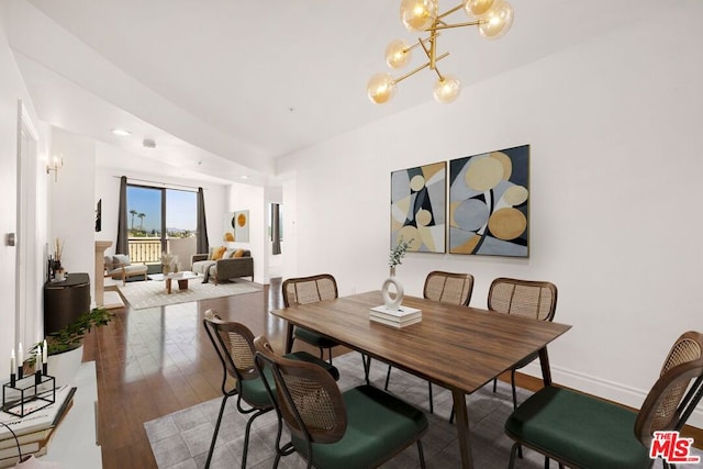 dining room with dark hardwood / wood-style flooring and a notable chandelier