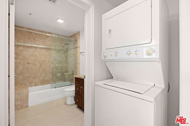 washroom with stacked washer and clothes dryer and light tile patterned floors