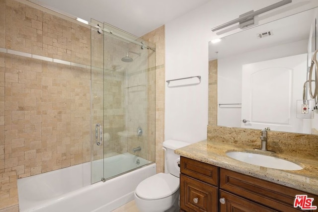 full bathroom with vanity, enclosed tub / shower combo, and toilet