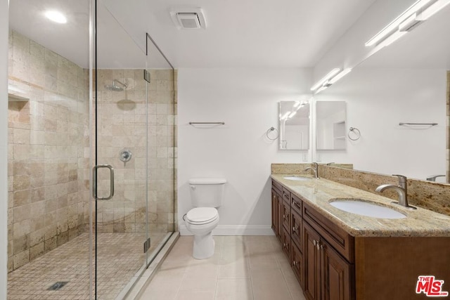 bathroom with tile patterned flooring, vanity, toilet, and a shower with shower door