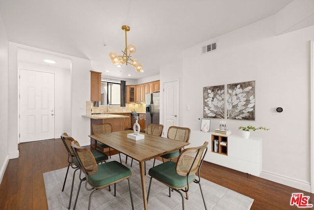 dining room with dark hardwood / wood-style floors and a chandelier