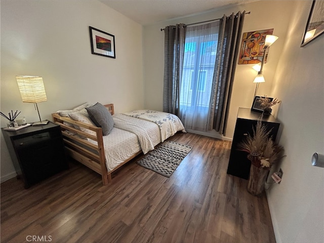 bedroom with dark hardwood / wood-style flooring