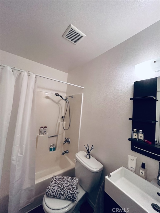 full bathroom with sink, shower / bathtub combination with curtain, a textured ceiling, and toilet