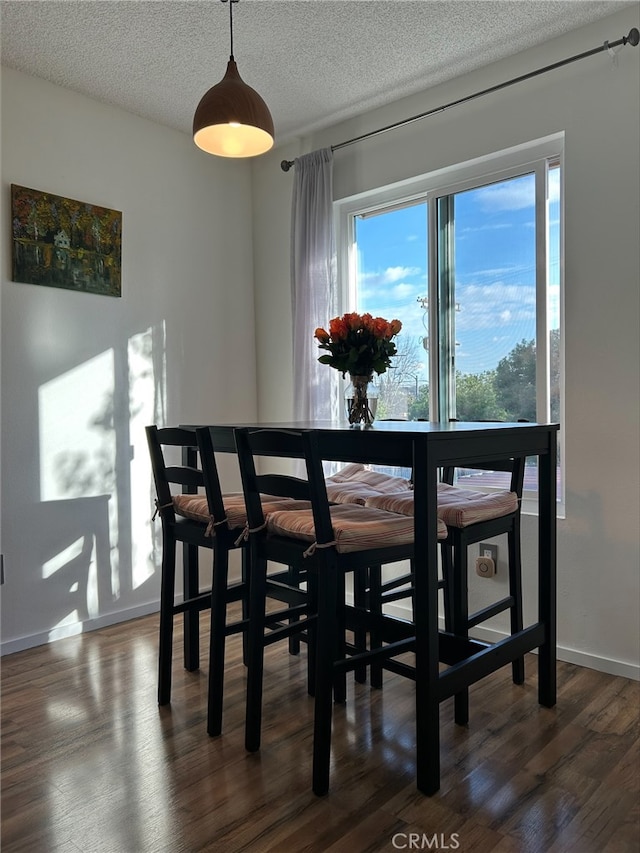 dining area with dark hardwood / wood-style floors and a textured ceiling