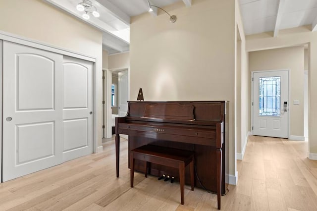 miscellaneous room with beamed ceiling and light hardwood / wood-style floors