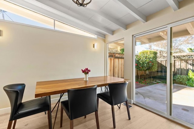 dining area with lofted ceiling with beams and light hardwood / wood-style flooring